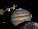 Rappresentazione asrtistica della sonda Jupiter fra Giove e alcune delle sue lune (fonte: ESA) (ANSA)