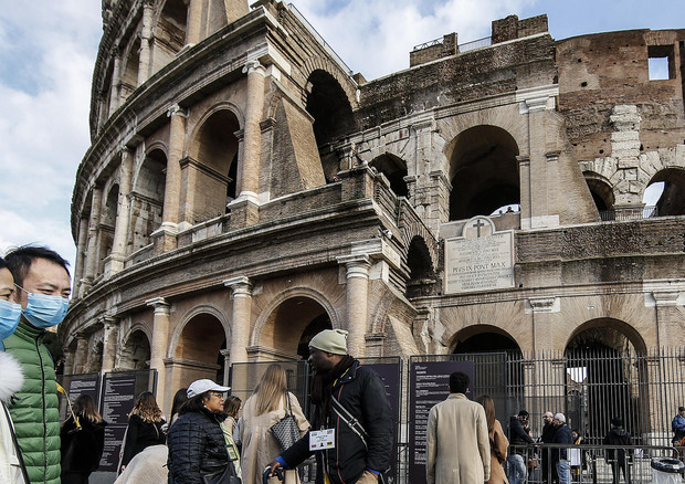 Turisti con mascherina davanti al Colosseo, Roma 2 febbraio 2020. ANSA/FABIO FRUSTACI © ANSA