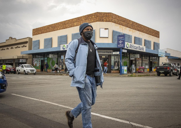 Un uomo passeggia per le strade di Parys, Sudafrica, nel pieno della diffusione della variante del coronavirus B.1.1.529 © EPA