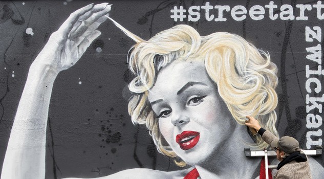 German street art artist TASSO (Jens Mueller) completes his new work, a graffito wall painting showing Hollywood star Marilyn Monroe during the official opening in Zwickau, eastern Germany, Saturday, Oct. 7, 2017.