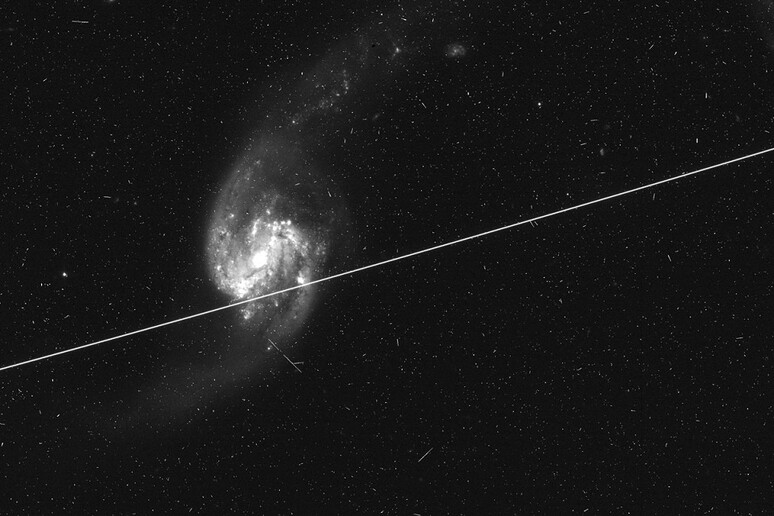 L’immagine di una galassia attraversata dalla scia luminosa di satelliti (fonte: Nasa/Esa Hubble/Kruk et al.) - RIPRODUZIONE RISERVATA