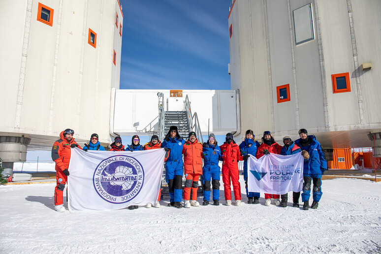 I 13 ricercatori e tecnici della campgna di ricerca invernale, alle loro spalle le due torri della base Concordia (fonte: ENEA) -     RIPRODUZIONE RISERVATA