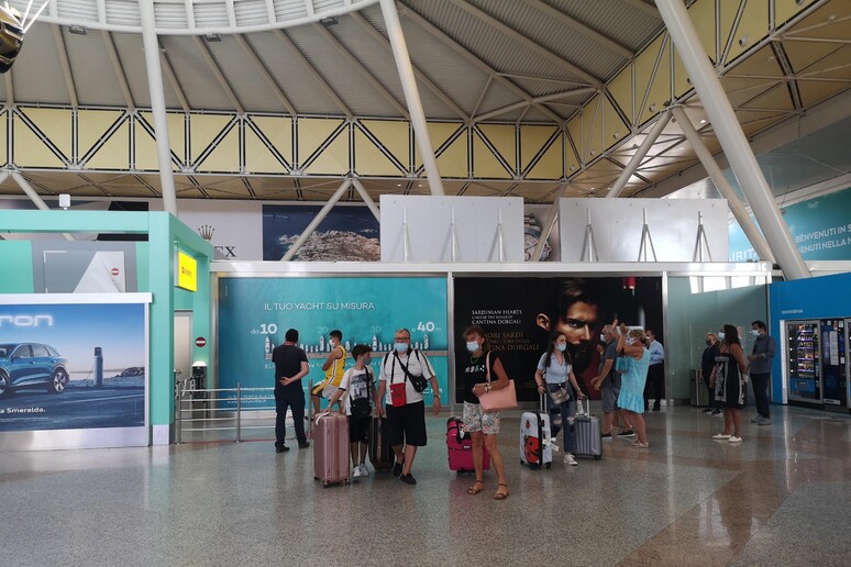 Turisti in aeroporto Olbia - RIPRODUZIONE RISERVATA
